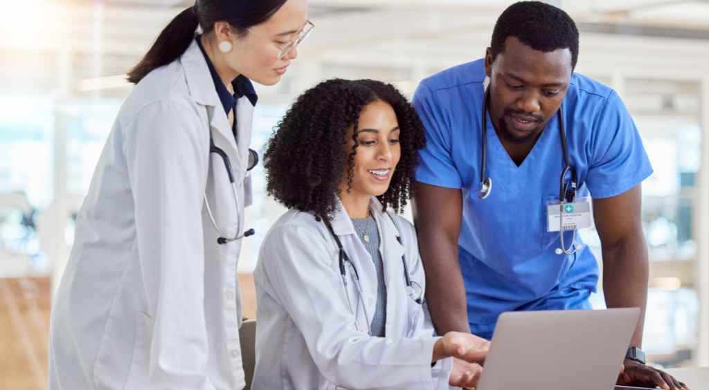 Doctors reviewing patient record and coordinating care at computer Doctors reviewing patient medical record and coordinating care at computer