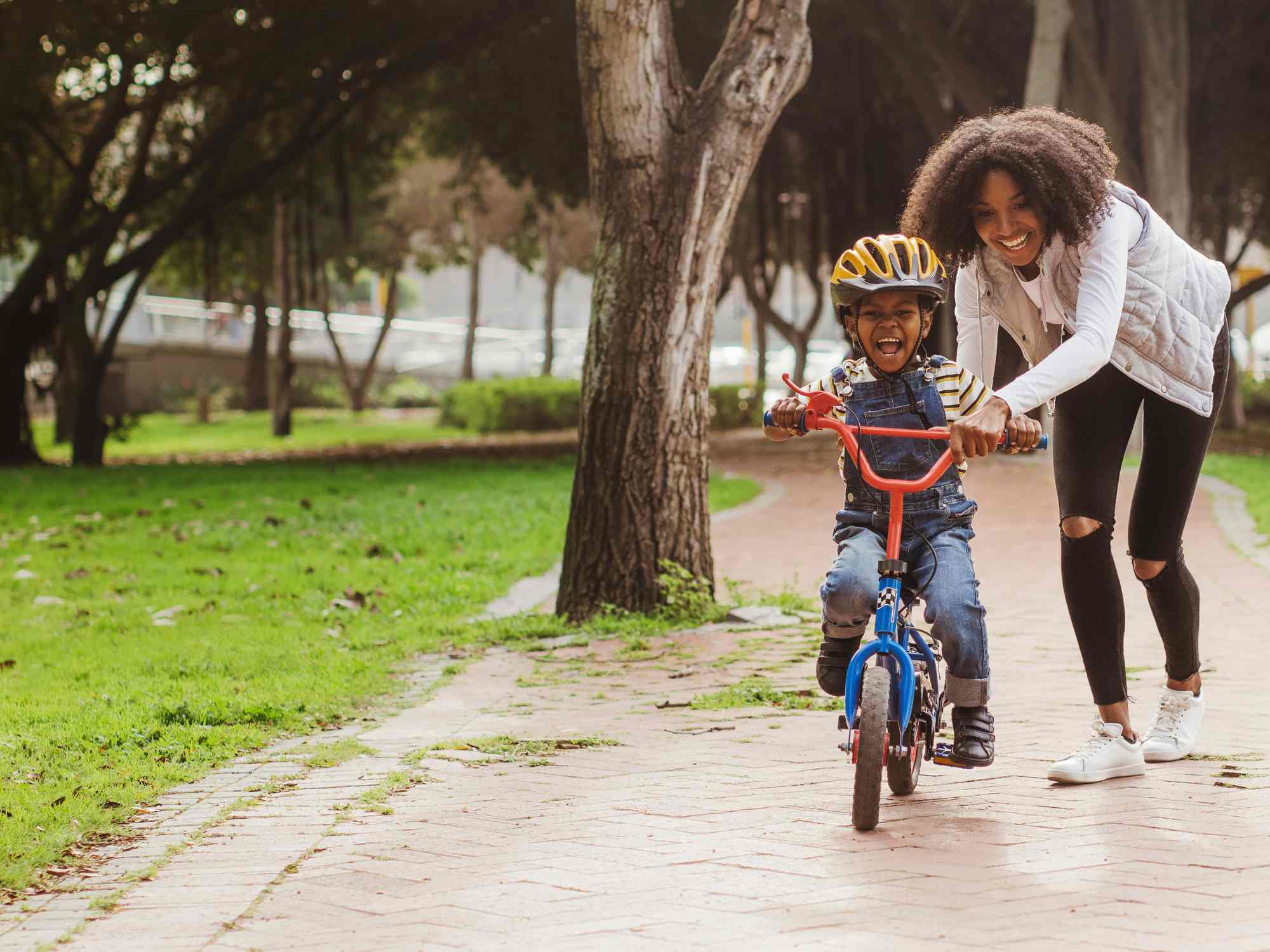 Child learning to ride bike on a path