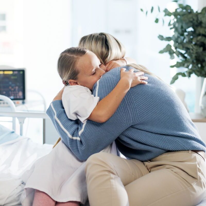 Mother hugging daughter in hospital
