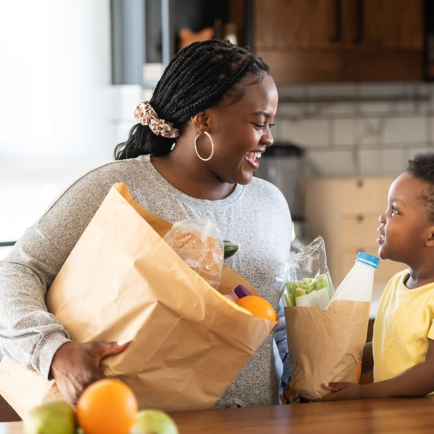 Mom and son with groceries in kitchen